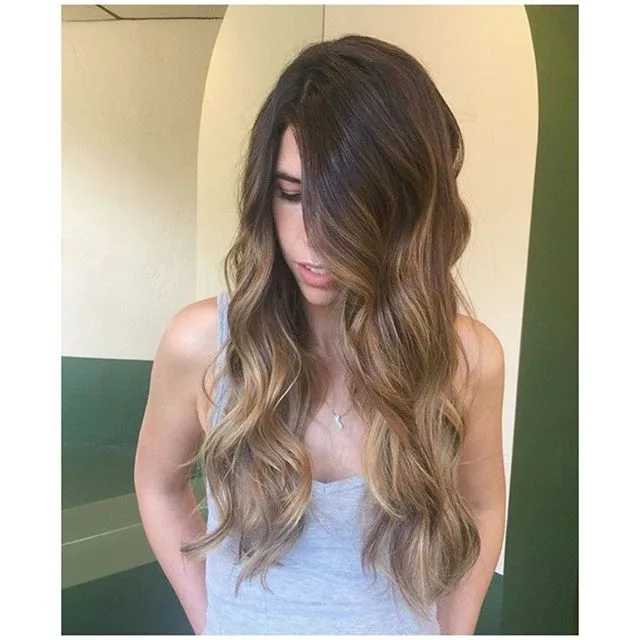Brunette to caramel balayage waves before a cream studio arch